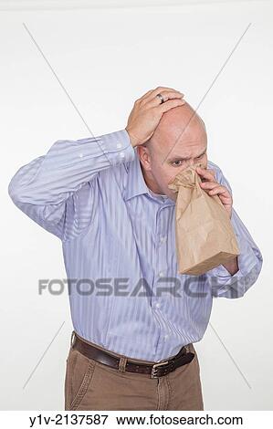 Middle-age bald man blowing into a paper bag. View Large Photo Image Stock Photo - Middle-age bald man blowing into a paper bag.. Fotosearch