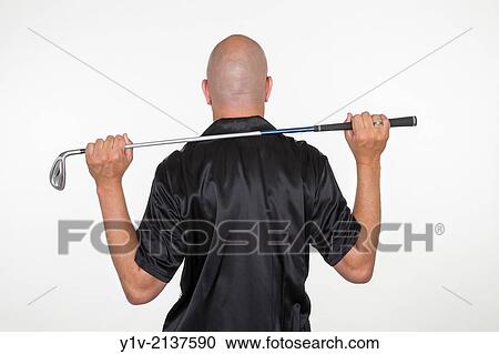Stock Image - Middle-age bald man holding a golf club.. Fotosearch