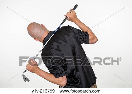 Stock Image - Middle-age bald man holding a golf club.. Fotosearch
