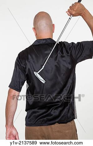 Stock Photo - Middle-age bald man holding a golf club.. Fotosearch