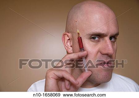 Middle-age bald man holding a syringe View Large Photo Image Stock Photo - Middle-age bald man holding a syringe. Fotosearch