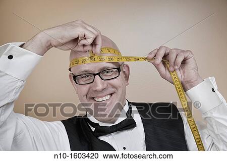 Middle-age bald man measuring his head View Large Photo Image Stock Image - Middle-age bald man measuring his head. Fotosearch