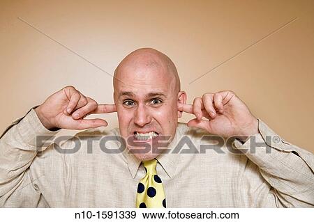 Stock Photo - Middle-age bald man with his fingers in his ear. Fotosearch
