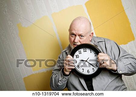 Middle-age balding man holding a clock View Large Photo Image Picture - Middle-age balding man holding a clock. Fotosearch