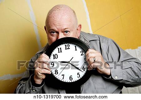Middle-age balding man holding a clock View Large Photo Image Stock Image - Middle-age balding man holding a clock. Fotosearch