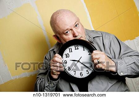Middle-age balding man holding a clock View Large Photo Image Stock Image - Middle-age balding man holding a clock. Fotosearch