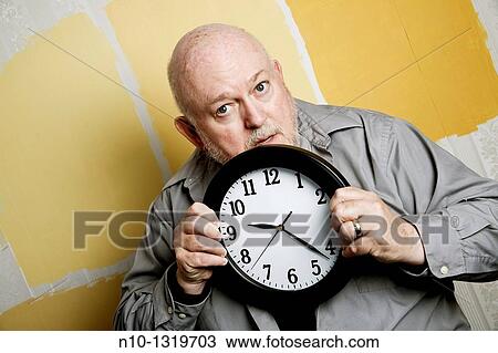 Middle-age balding man holding a clock View Large Photo Image Stock Image - Middle-age balding man holding a clock. Fotosearch