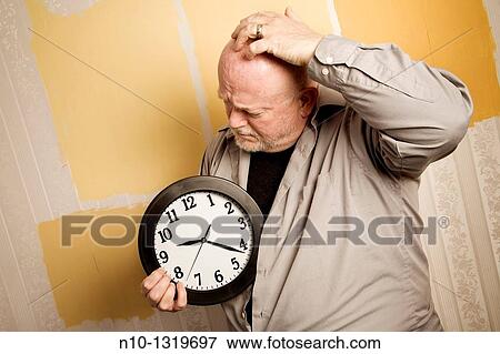 Middle-age balding man holding a clock View Large Photo Image Stock Photo - Middle-age balding man holding a clock. Fotosearch