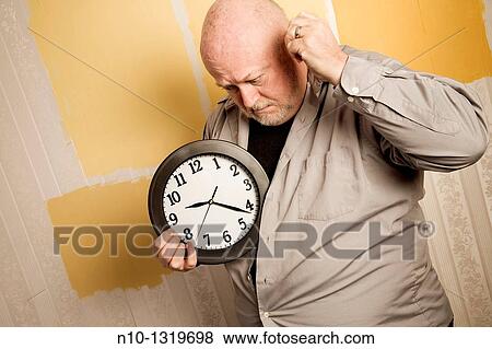 Middle-age balding man holding a clock View Large Photo Image Stock Photo - Middle-age balding man holding a clock. Fotosearch