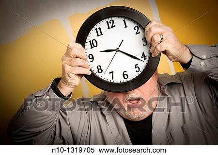 Middle-age balding man holding a clock View Large Photo Image Stock Photography - Middle-age balding man holding a clock. Fotosearch