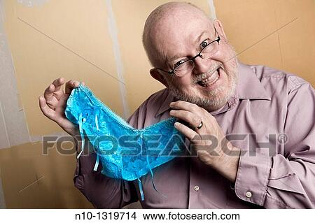 Middle-age balding man holding a pair of lady's panties View Large Photo Image Picture - Middle-age balding man holding a pair of lady's panties. Fotosearch