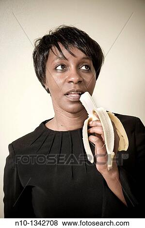 Middle-age black woman eating a banana View Large Photo Image Stock Photo - Middle-age black woman eating a banana. Fotosearch