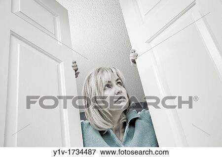 Middle-age blond woman looking out through double doors View Large Photo Image Stock Photo - Middle-age blond woman looking out through double doors. Fotosearch