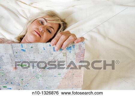 Middle-age blond woman reading a map in bed View Large Photo Image Stock Photograph - Middle-age blond woman reading a map in bed. Fotosearch