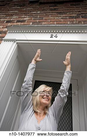 Middle-age blond woman standing by her front door View Large Photo Image Stock Photo - Middle-age blond woman standing by her front door. Fotosearch