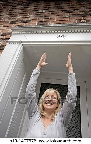 Middle-age blond woman standing by her front door View Large Photo Image Stock Photograph - Middle-age blond woman standing by her front door. Fotosearch