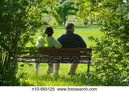 Middle age couple sitting on a bench at a park. View Large Photo Image Stock Photography - Middle age couple sitting on a bench at a park.. Fotosearch