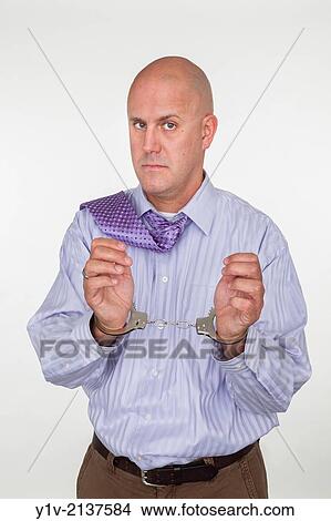 Picture - Middle-age man bald man in handcuffs.. Fotosearch