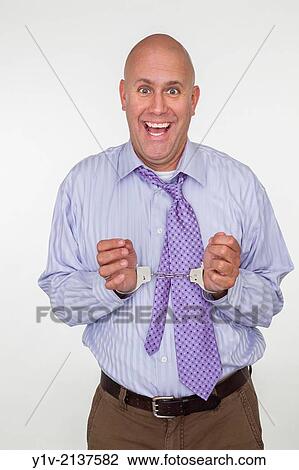 Stock Image - Middle-age man bald man in handcuffs.. Fotosearch
