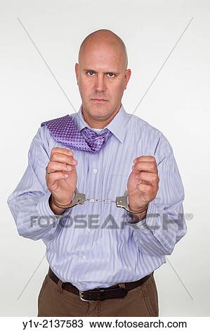 Stock Image - Middle-age man bald man in handcuffs.. Fotosearch