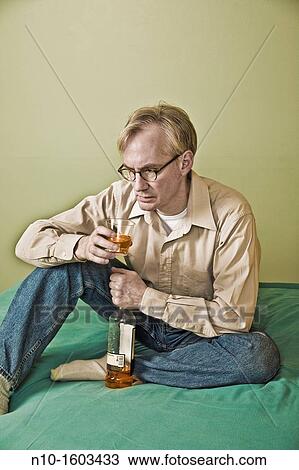 Middle-age man holding a bottle and a glass of liquor View Large Photo Image Stock Image - Middle-age man holding a bottle and a glass of liquor. Fotosearch