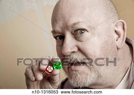 Middle-age man holding a pair of dice View Large Photo Image Stock Image - Middle-age man holding a pair of dice. Fotosearch