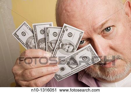 Middle-age man holding small copies of American money View Large Photo Image Stock Image - Middle-age man holding small copies of American money. Fotosearch