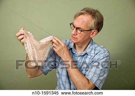 Middle-age man holding up a pair of woman's panties View Large Photo Image Stock Photography - Middle-age man holding up a pair of woman's panties. Fotosearch