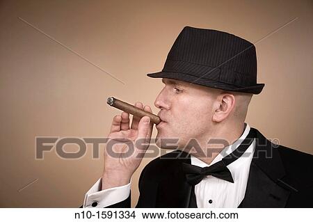 Middle-age man in a tuxedo, with a hat and cigar View Large Photo Image Picture - Middle-age man in a tuxedo, with a hat and cigar. Fotosearch