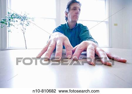 Middle-age man sitting at a table View Large Photo Image Stock Image - Middle-age man sitting at a table. Fotosearch
