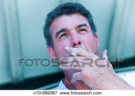 Middle-age man smoking a cigarette. View Large Photo Image Stock Photo - Middle-age man smoking a cigarette.. Fotosearch