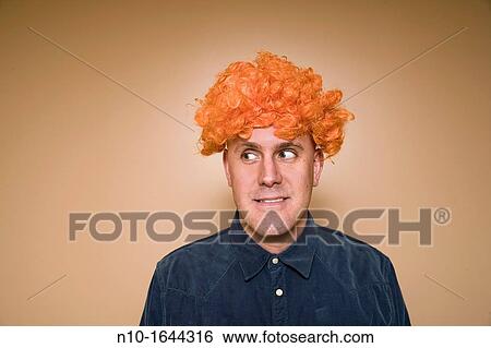 Stock Photograph - Middle-age man wearing an orange wig. Fotosearch