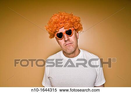 Middle-age man wearing an orange wig and heart-shaped sunglasses View Large Photo Image Stock Photography - Middle-age man wearing an orange wig and heart-shaped sunglasses. Fotosearch