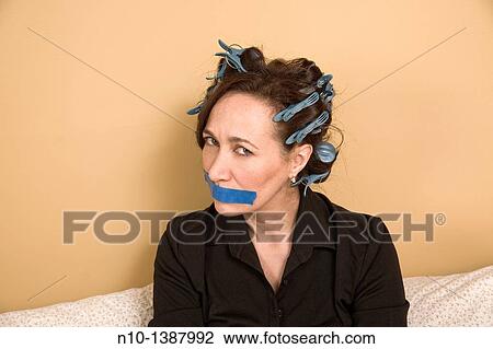 Middle-age woman in curlers, with tape over her mouth View Large Photo Image Stock Image - Middle-age woman in curlers, with tape over her mouth. Fotosearch
