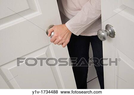 Stock Photo - Middle-age woman's hand on a door handle. Fotosearch