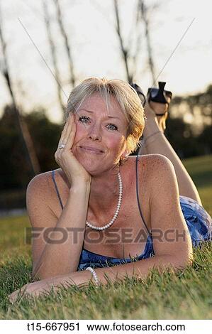 Middle aged blond woman dressed up playfully on the grass to enjoy the sunset or sunrise View Large Photo Image Stock Image - Middle aged blond woman dressed up playfully on the grass to enjoy the sunset or sunrise. Fotosearch