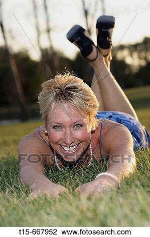 Middle aged blond woman dressed up playfully on the grass to enjoy the sunset or sunrise View Large Photo Image Stock Image - Middle aged blond woman dressed up playfully on the grass to enjoy the sunset or sunrise. Fotosearch