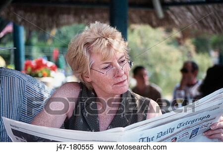 Middle aged female, reading newspaper View Large Photo Image Stock Photography - Middle aged female, reading newspaper. Fotosearch