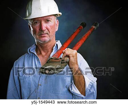 Middle-aged laborer holding bold cutters View Large Photo Image Stock Image - Middle-aged laborer holding bold cutters. Fotosearch