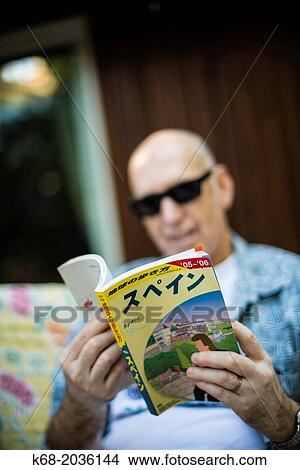 middle-aged man looks at a Japanese book View Large Photo Image Picture - middle-aged man looks at a Japanese book. Fotosearch