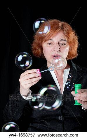 Middle aged woman blowing bubbles View Large Photo Image Stock Photo - Middle aged woman blowing bubbles. Fotosearch