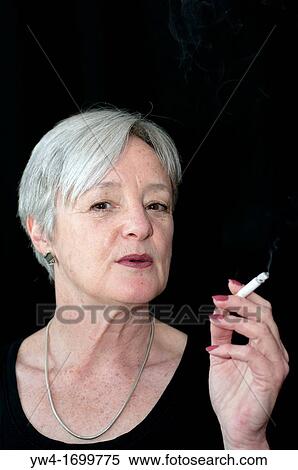 Middle aged woman smoking a cigarette View Large Photo Image Stock Photography - Middle aged woman smoking a cigarette. Fotosearch