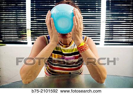 Middle aged woman, with striped shirt with blue glass bowl, drinking and covering her face. View Large Photo Image Stock Image - Middle aged woman, with striped shirt with blue glass bowl, drinking and covering her face.. Fotosearch