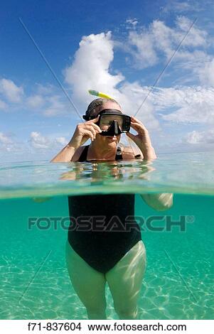 Middle aged women in one piece swim suit snorkelling over sandy on tropical beach. Ha`apai Group, Tonga. South Pacific Ocean. View Large Photo Image Picture - Middle aged women in one piece swim suit snorkelling over sandy on tropical beach. Ha`apai Group, Tonga. South Pacific Ocean.. Fotosearch