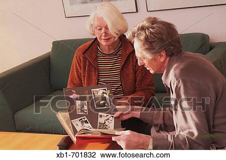 Middleaged couple is looking at photo album View Large Photo Image Stock Image - Middleaged couple is looking at photo album. Fotosearch