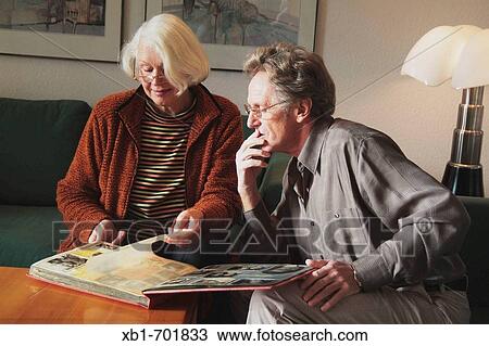 Middleaged couple is looking at photo album View Large Photo Image Stock Image - Middleaged couple is looking at photo album. Fotosearch