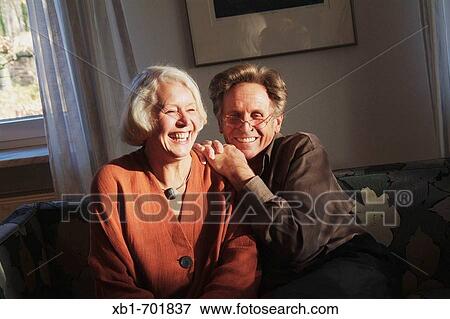 Middleaged couple is sitting on a couch View Large Photo Image Stock Photo - Middleaged couple is sitting on a couch. Fotosearch