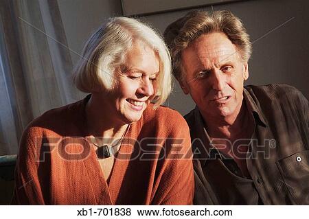 Middleaged couple is sitting on a couch View Large Photo Image Stock Photo - Middleaged couple is sitting on a couch. Fotosearch