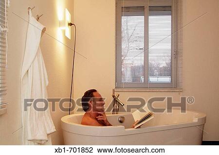 Middleaged man is reading a book in a bathtub View Large Photo Image Stock Image - Middleaged man is reading a book in a bathtub. Fotosearch