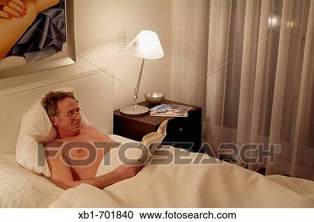 Middleaged man is reading a book in bed View Large Photo Image Stock Image - Middleaged man is reading a book in bed. Fotosearch